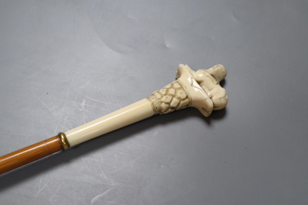 An early 20th century ivory sphinx parasol handle, 84cm